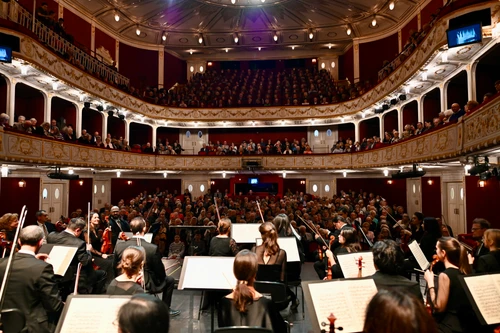 Voll besetzter prunkvoller Saal aus Sicht des Orchesters auf der Bühne