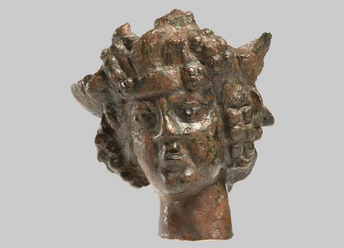 The head of the youthful Bacchus is adorned with a headband, vine leaves, and grapes.