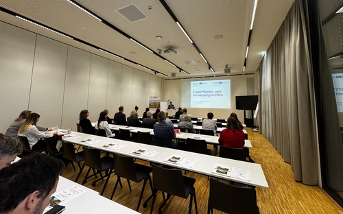 Photo of the Roman Legacy Project expert meeting, showing the room with people seated and a PowerPoint slide in the foreground