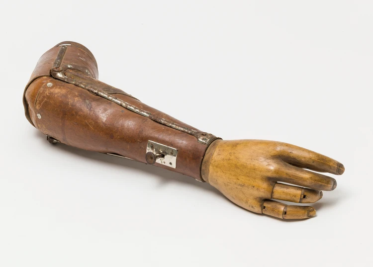 Armprothese des Soldaten Nachförg, 1914
Die Armprothese tammt aus dem Privatbesitz des Großvaters des Schenkers, Herrn Nachförg, welcher als Soldat im Ersten Weltkrieg seinen rechten Arm verlor. Als selbstständiger Landwirt des Waldviertels bedeutete dies nach seiner Rückkehr eine immanente existienzielle Bedrohung. Um seinen täglichen Arbeiten trotz dem Verlust seines rechten Arms nachgehen zu können, ließ er sich bei den Prothesen Werkstätten des k.u.k. Reserve Spital No. 11 in Wien V, Gassergasse 44-46, mehrere Armprothesen anfertigen. Unter anderem berichtet seine Enkel darüber, dass er eine eigene Prothesenanfertigung mit Sensenaufsatz besaß. Die als Schenkung erhaltene Armprothese trug Herr Nachförg bei Kirchenbesuchen oder anderen Feierlichkeiten.