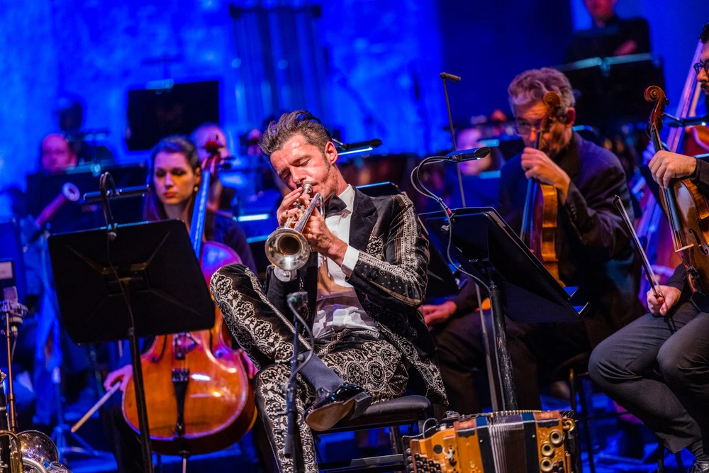 Mann spielt in Orchester sitzend Trompete