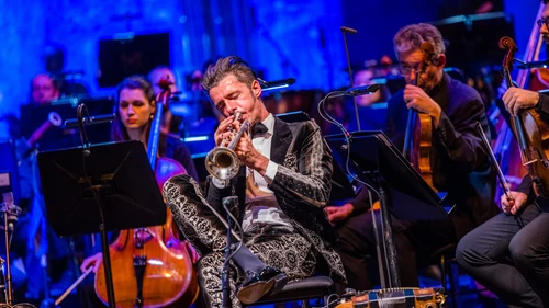 Mann spielt in Orchester sitzend Trompete