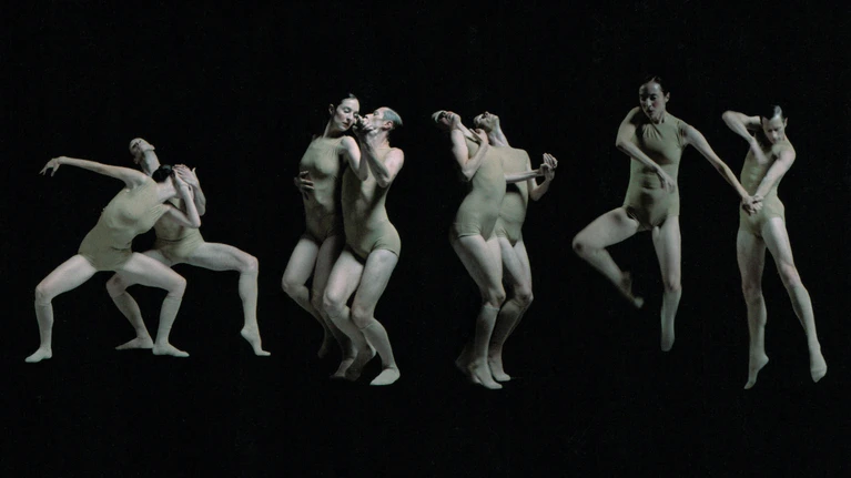 Dancers – some in pairs, some alone – dancing side by side against a black background as part of Sharon Eyal's new dance piece ‘Delay the Sadness’, an exploration of the pas de deux.
