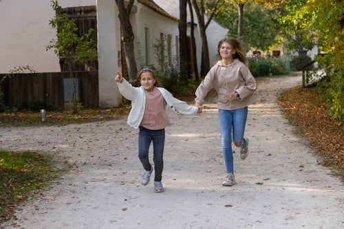 Zwei Mädchen rennen durch das Museumsdorf