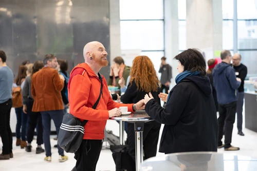 Gruppe von Menschen ubnterhält sich in eienr Ausstellung