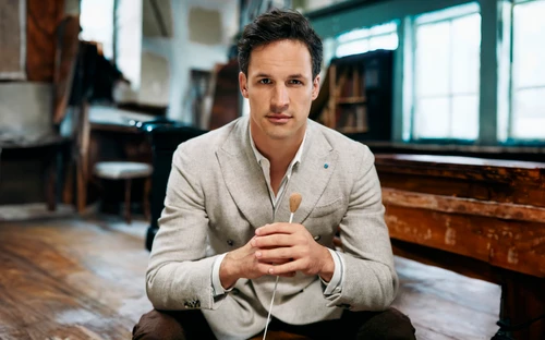 Portrait photo of conductor Andreas Otensamer with baton.