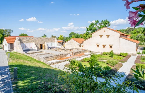 Reconstruction of a Roman villa with garden and flowering plants under a blue sky