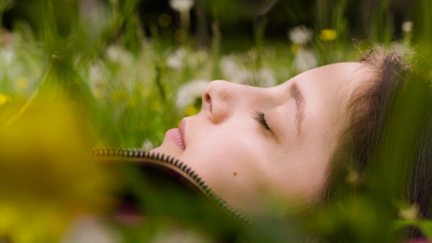 Ein Mädchen liegt in der Wiese