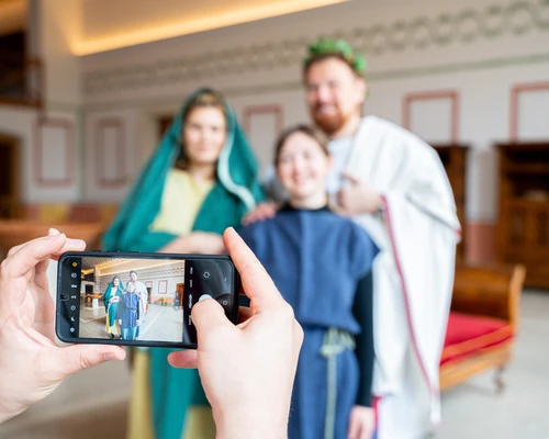 People in historical costumes pose for a photo in an antique setting.