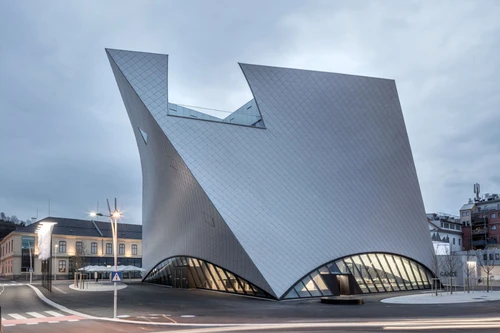Landesgalerie Niederösterreich: skulpturaler, silberverkleideter Bau mit schrägen Flächen in der Dämmerung.
