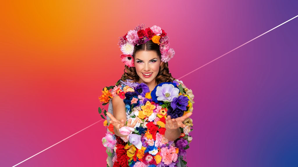 A person is entirely adorned with colorful flowers, including a floral crown, set against a gradient background.