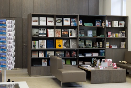 Raumansicht des Museumsshops mit Regalen voller Bücher, Schmuck, Keramik und weiteren Designartikeln