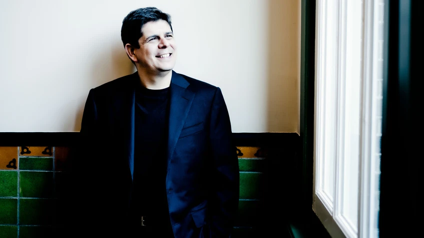 Photo of pianist Javier Perianes, seen wearing a black suit with a black shirt underneath. 