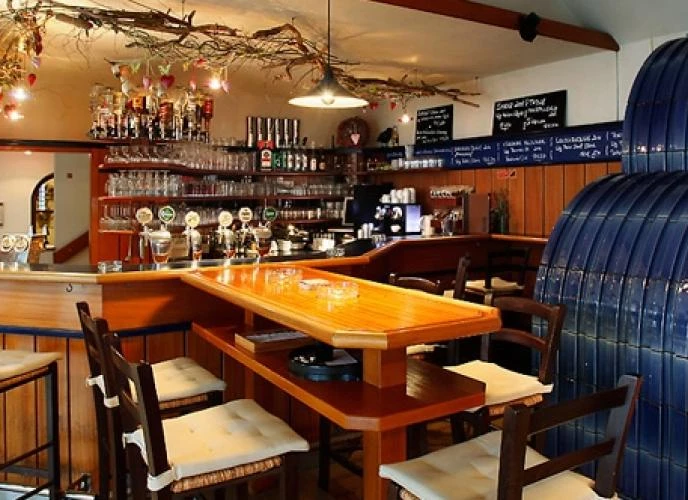 Gasthausraum mit Tisch und Stühlen und Bar