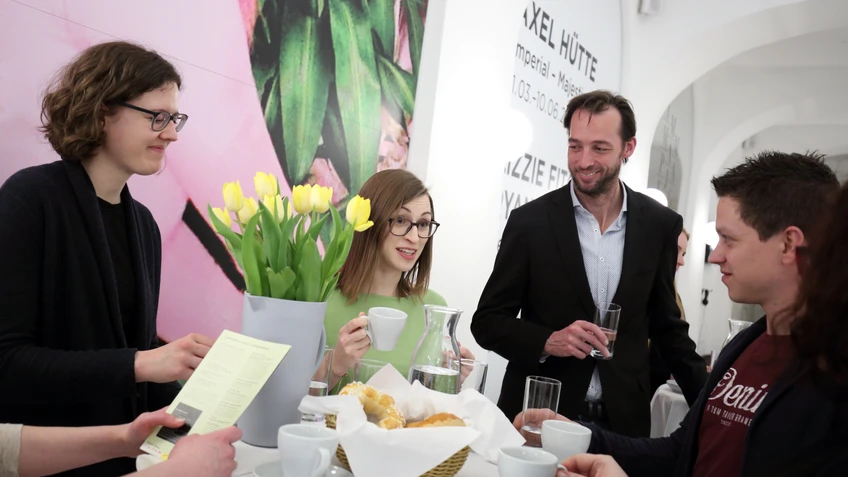 Vier Personen im Foyer der Kunsthalle Krems mit Kaffee und Kipferl