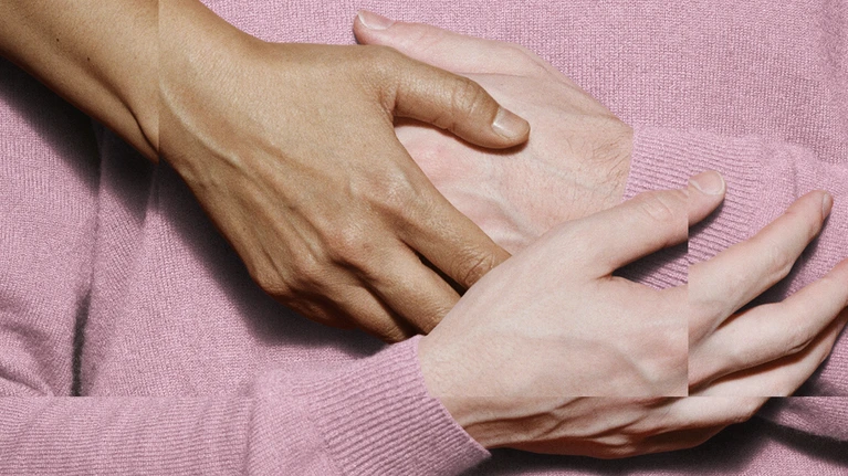 The theme for the Festspielhaus’s 2026/2027 season. The image shows hands touching against a pink background, which derives from the colour of the jumper worn by a person whose arms are crossed in front of their torso.