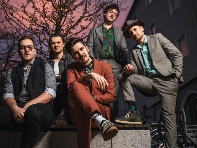 The photograph shows a child jumping up and down – various cages are hanging from the ceiling, with handmade birds sitting inside them.