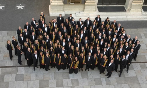 Gruppenfoto vom Wiener Singverein in formeller Kleidung, aufgenommen aus der Vogelperspektive.