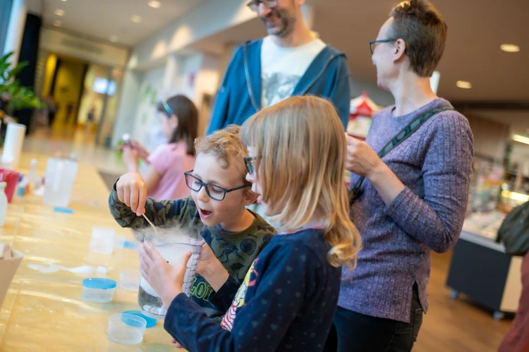Kinder staunen über ein Experiment.