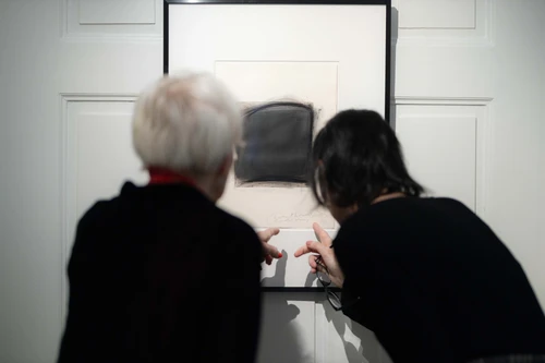 Besucher und Besucherinnen betrachten Kunstwerke