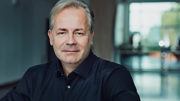 Mann mit grauem Haar und dunkelblauem Hemd
