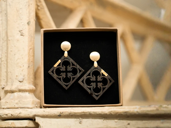 Ohrringe aus Holz mit Gold in einer Schachtel an einer alten Treppe