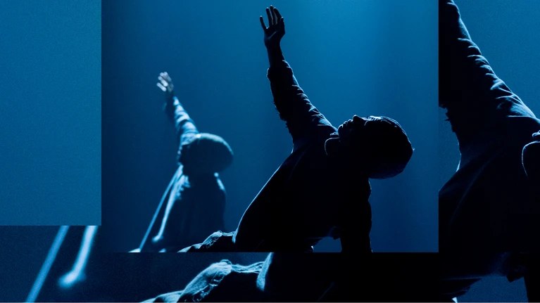 Performance photo from ‘Trailer Park’, choreographed by Moritz Ostruschnjak and performed by tanz mainz. The dancers are performing a floor-based movement, holding hands and wearing oversized sports jerseys.