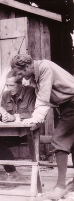 Die Archäologen Swoboda und Vorbeck bei einer Besprechung 1949 in Carnuntum, Swoboda sitzt an einem Tisch, Vorbeck schaut auf einen Plan, schwarzweiß Foto 