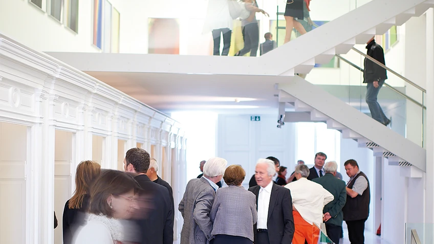 Besucher und Besucherinnen in den Ausstellungsräumen des Arnulf Rainer Museums.