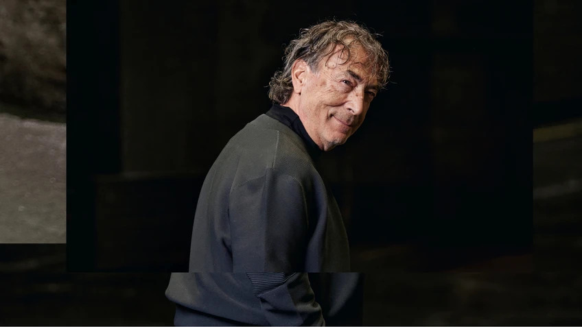 Portrait photo of Hubert von Goisern in front of a dark background.