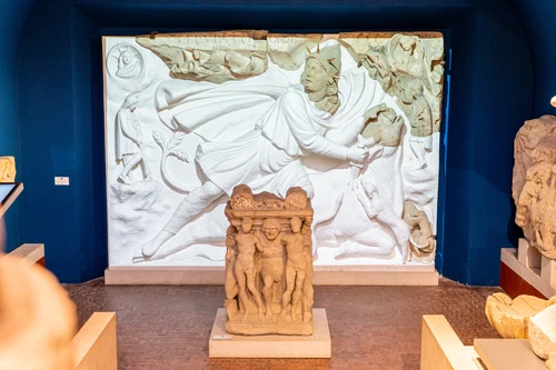 Mithras Relief in der Mithrasgrotte, unbeleuchtet, Jahreszeitenaltar davor 