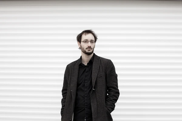 Portraitfoto von Jerome Junod vor einer neutralen Wand.