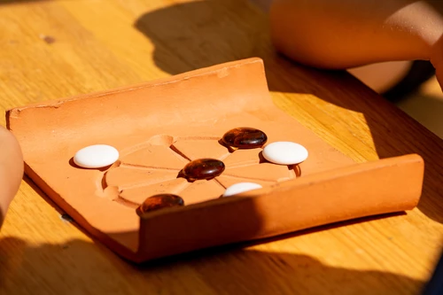 Round mill, clay board with black and white game pieces
