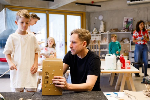 Künstler Kay Walkowiak unterhält sich mit einem Jungen über dessen Kunstwerk für Tiere.