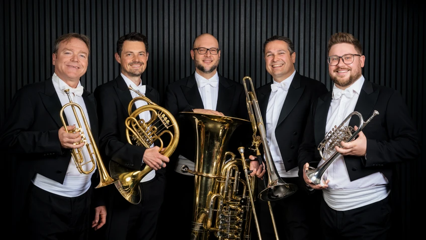 Fünf Musiker an Fräcken mit Blasinstrumenten