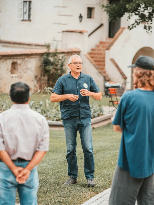 Cultural mediator standing in front of a group and talking. Green space in the background.