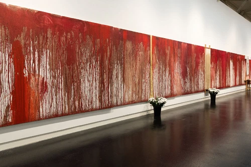 Großflächiges, rotes abstraktes Gemälde mit tropfender Farbstruktur an einer weißen Galeriewand.
