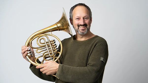 Portraitfoto von Christoph Peham mit Horn