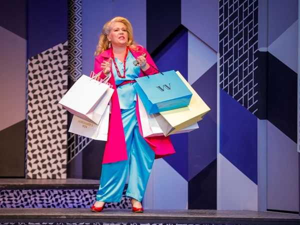 Lady with a blue dress and pink cape holding some shopping bags - background is blue with abstract pattern