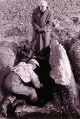 Vorbeck steht über einem Grab mit Sarkophag während ein Arbeiter das Grab ausschaufelt, schwarzweiß Foto
